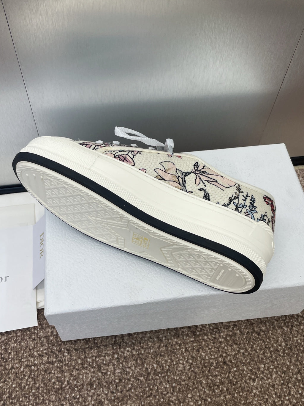 White unisex sneaker with botanical print upper and dark edge on sole