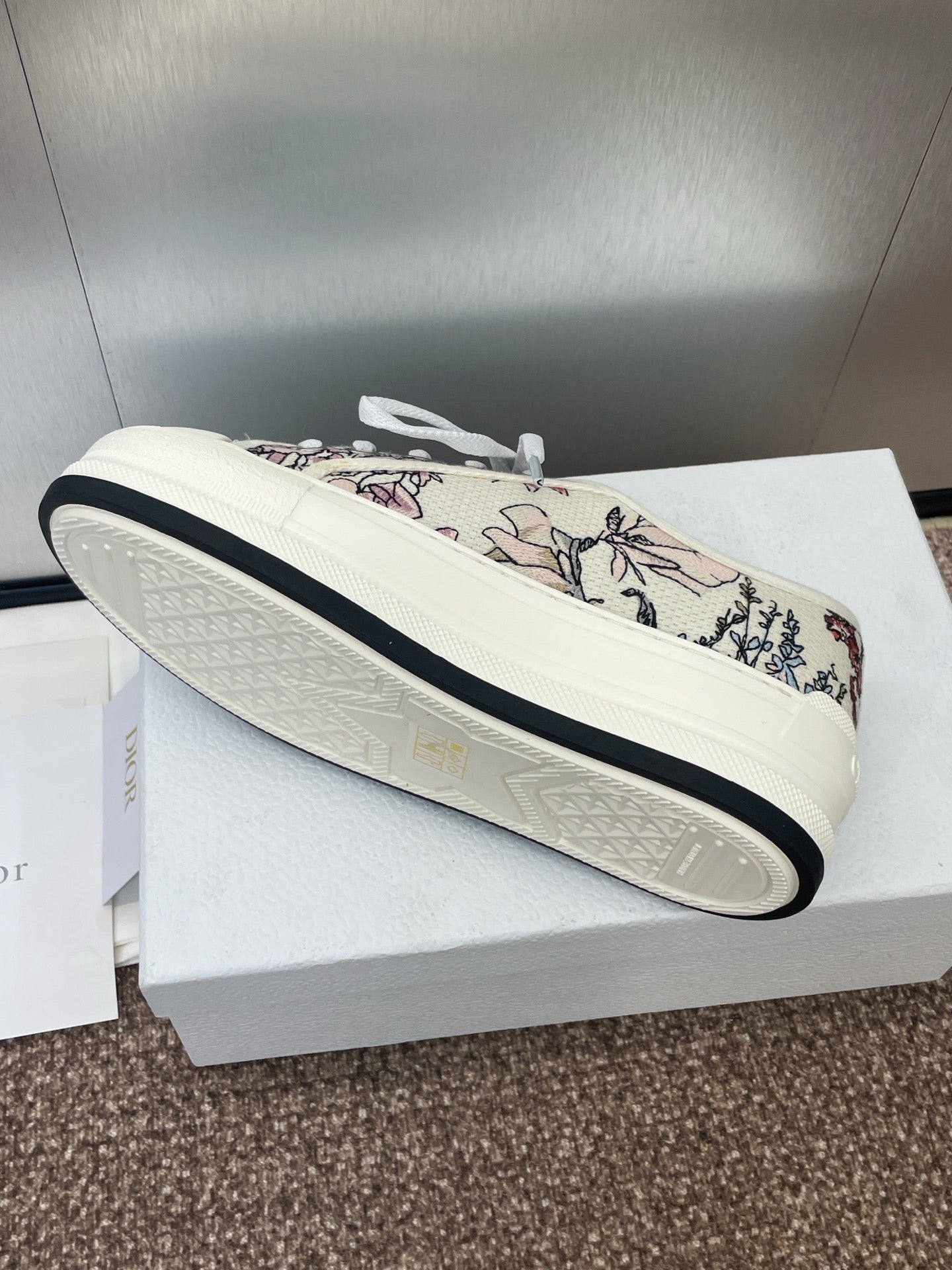 White unisex sneaker with botanical print upper and dark edge on sole