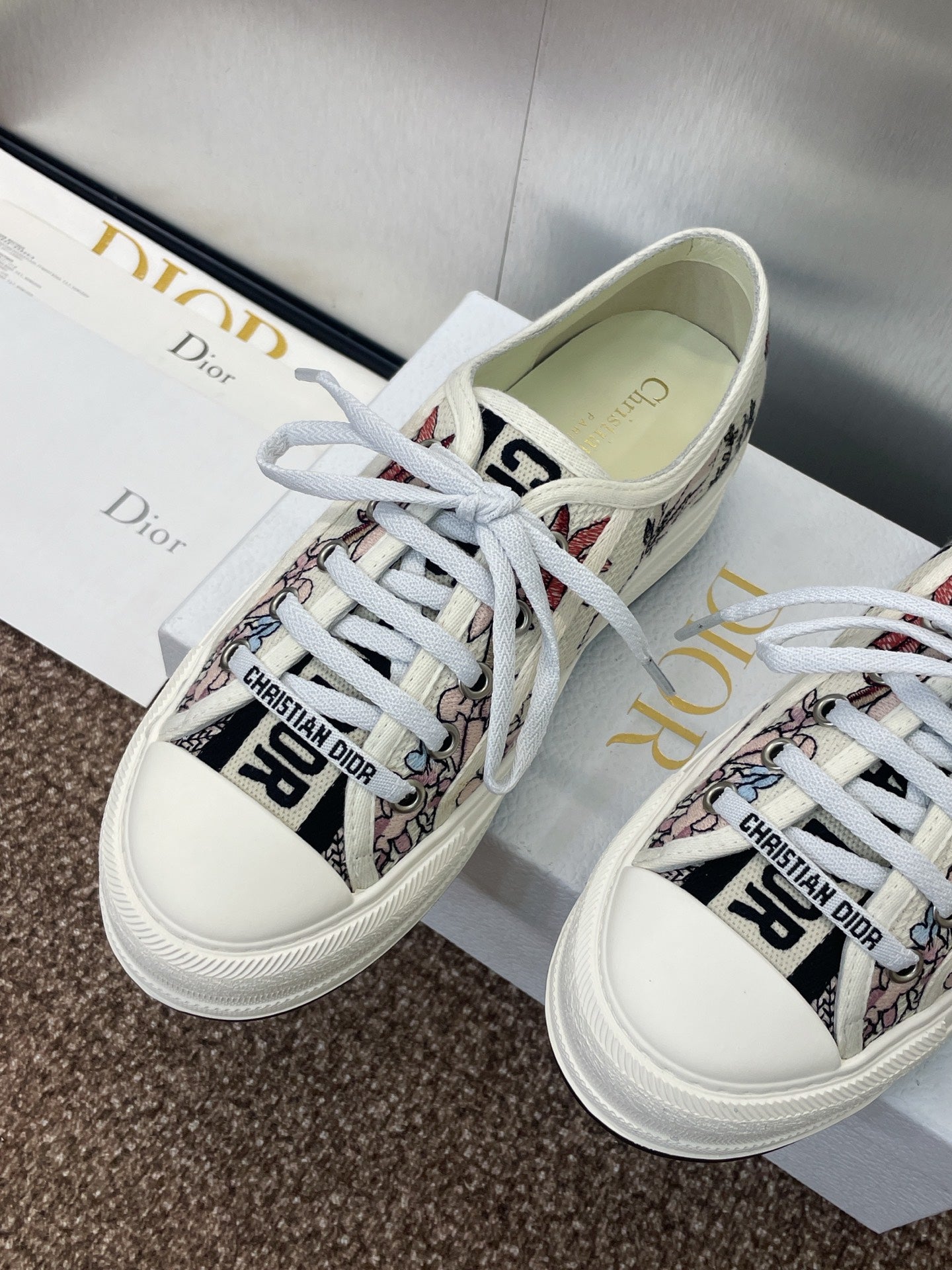 White unisex sneakers with botanical print, lace-up front, and Dior logo tongue