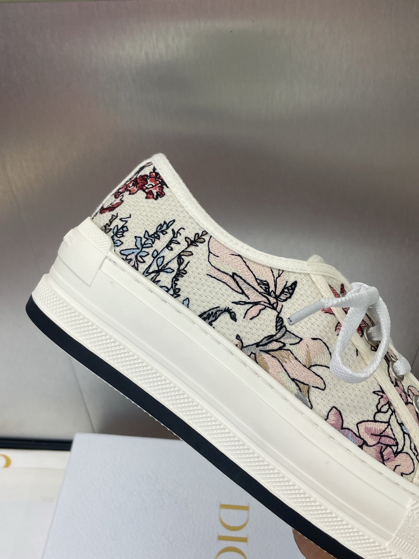 White unisex low-top sneakers with floral-printed canvas and dark trim sole