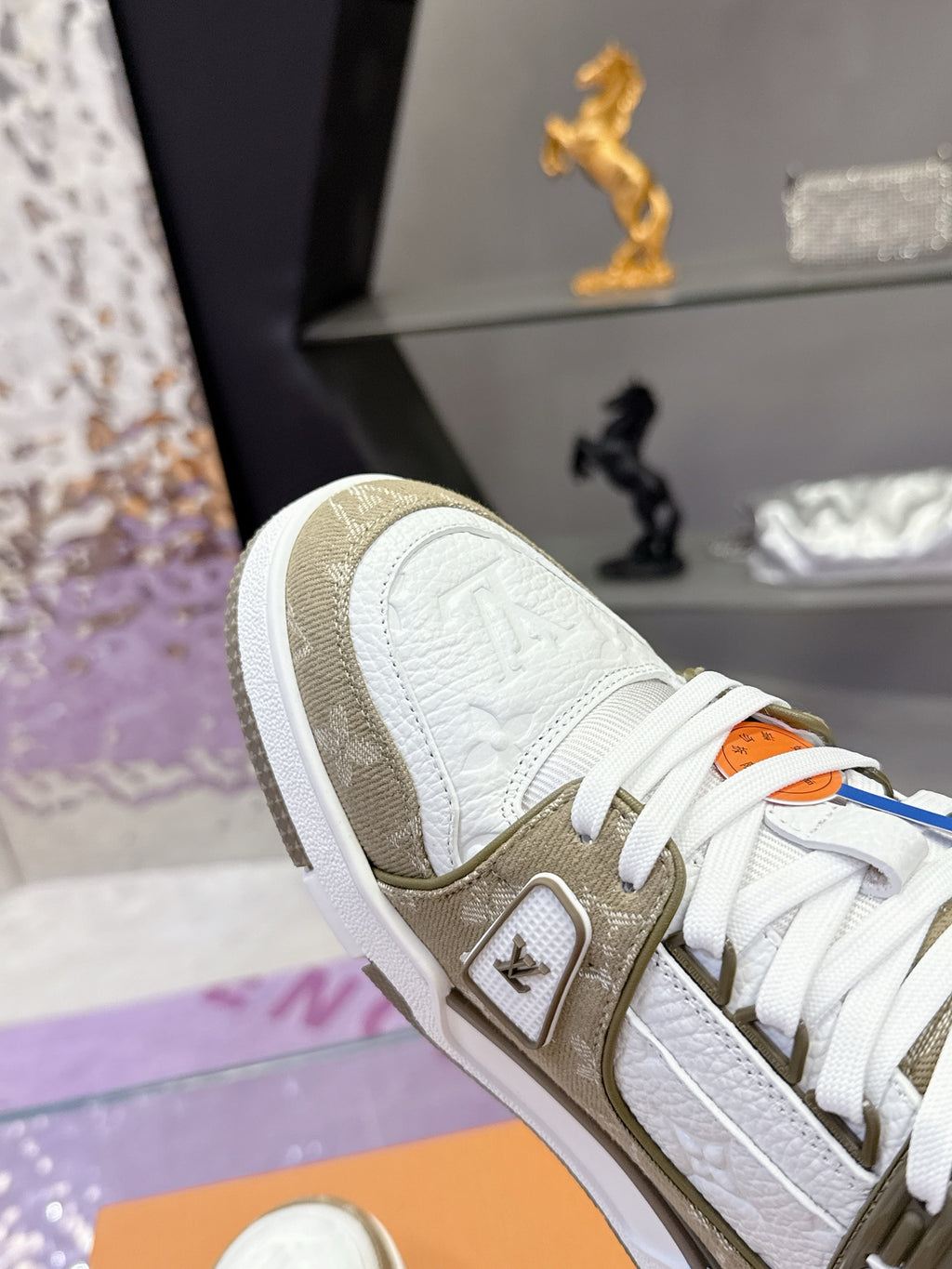 Women’s Louis Vuitton sneaker close-up: white leather, olive panel, white laces