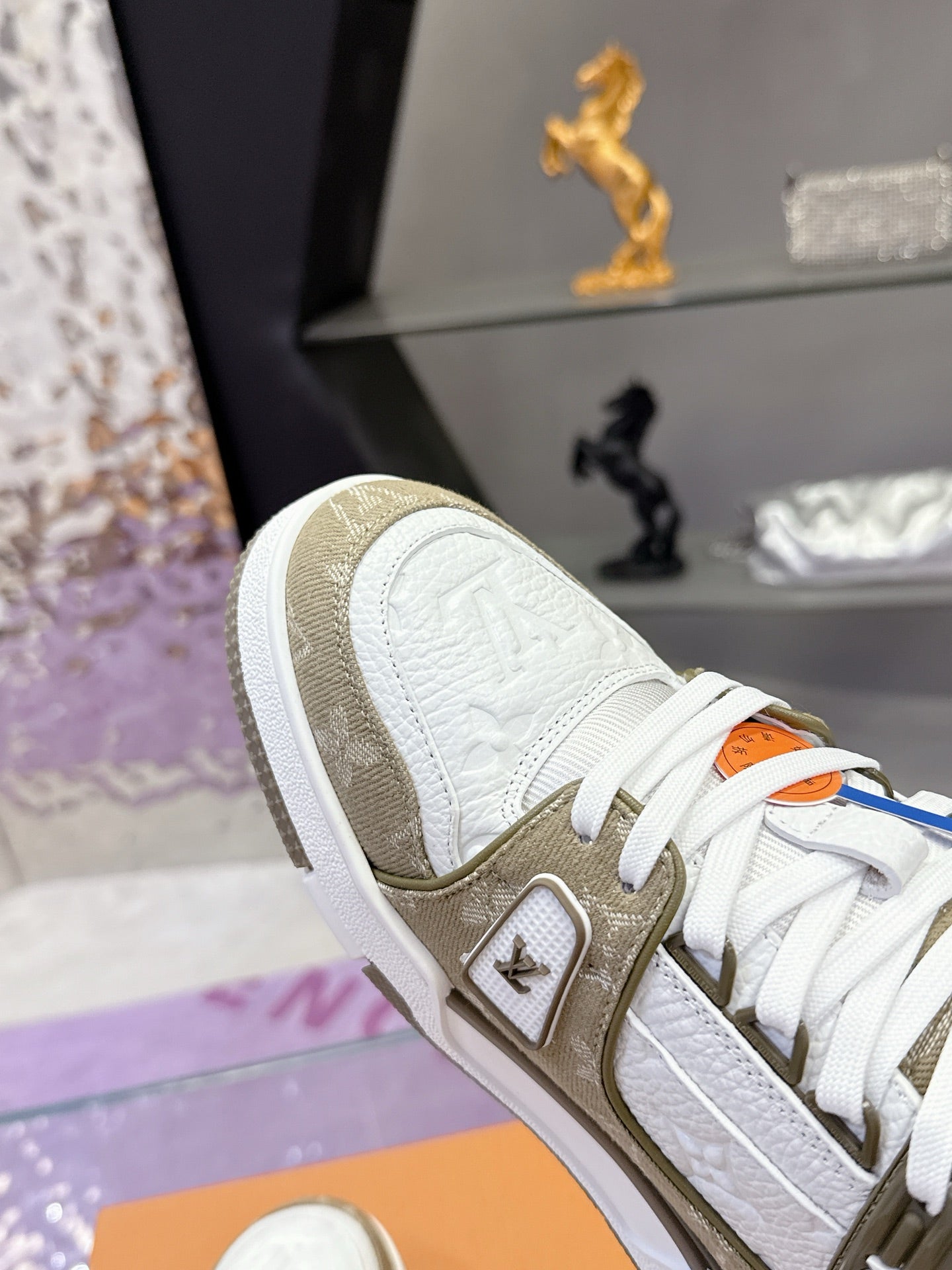 Women’s Louis Vuitton sneaker close-up: white leather, olive panel, white laces