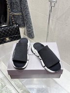 Balenciaga black slide sandals with knit straps and white chunky sole, front view