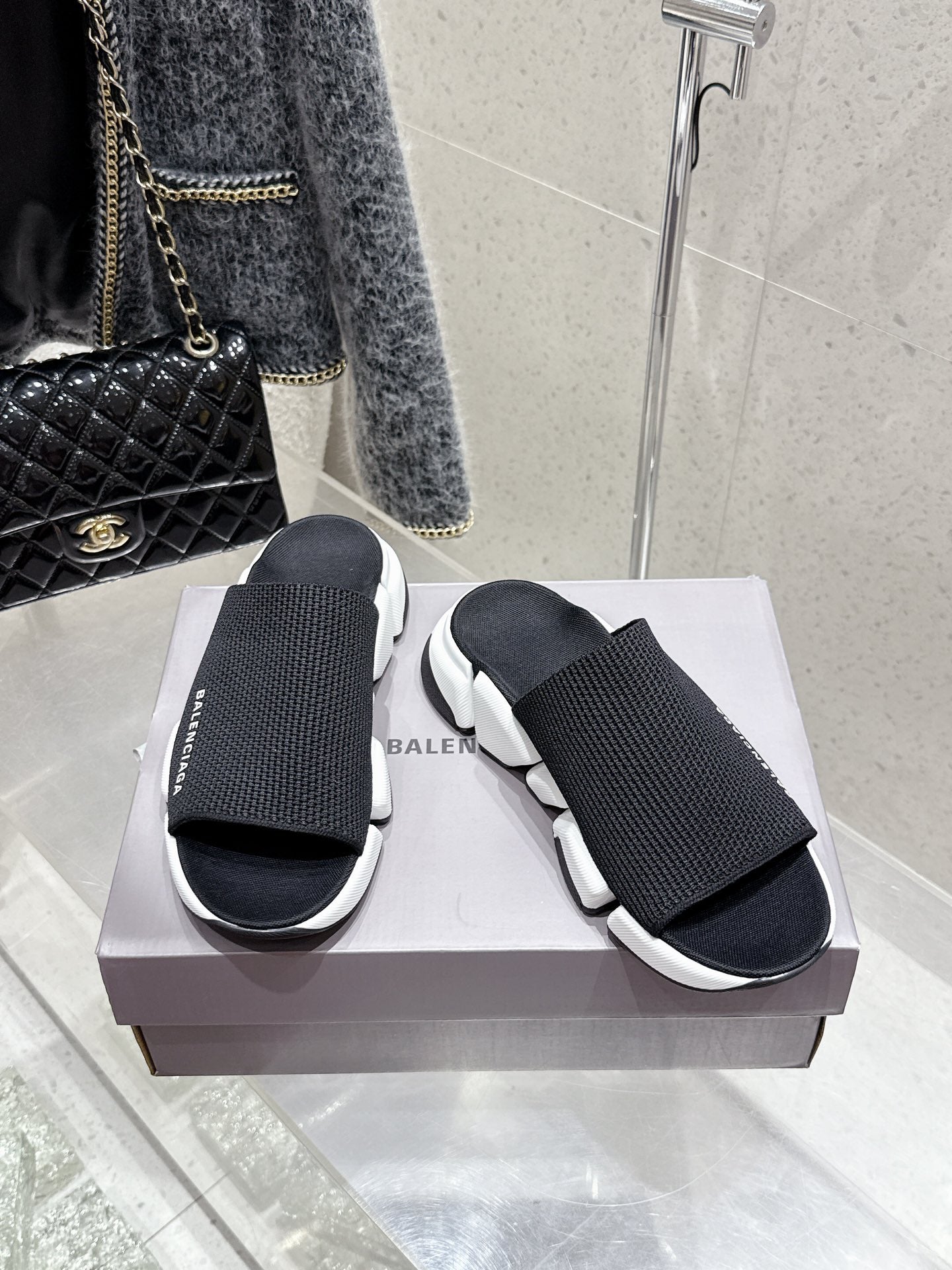 Balenciaga black slide sandals with knit straps and white chunky sole, front view