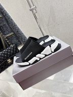Balenciaga black slide sandals with elastic knit strap and white sculpted sole, side view