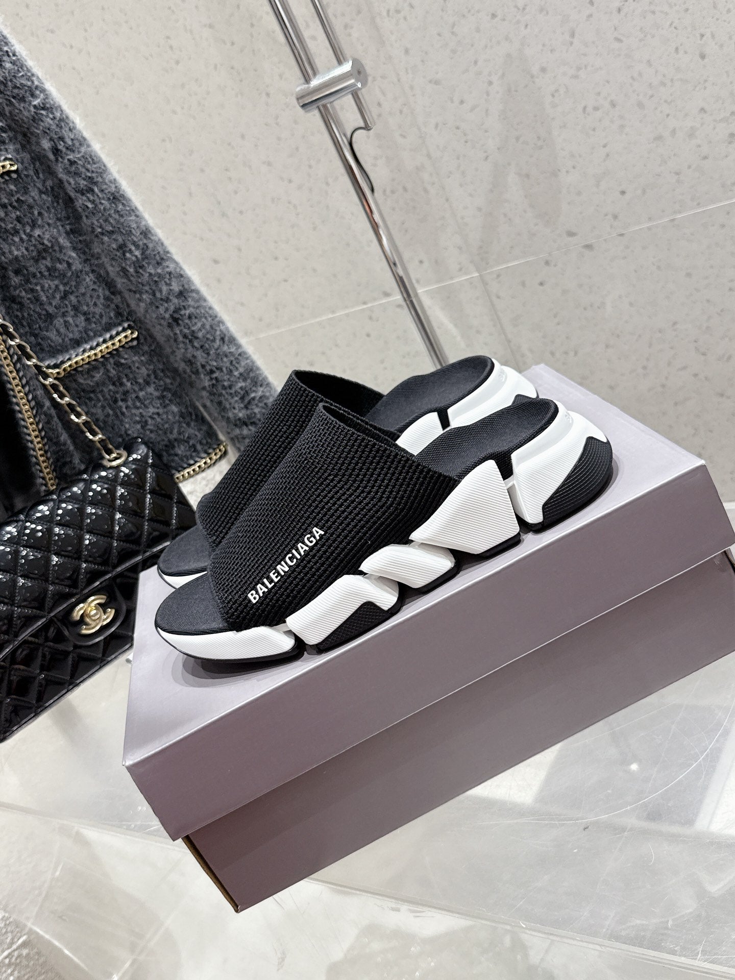 Balenciaga black slide sandals with elastic knit strap and white sculpted sole, side view