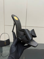 YSL black high-heel mule sandal with bow straps, close-up view on box