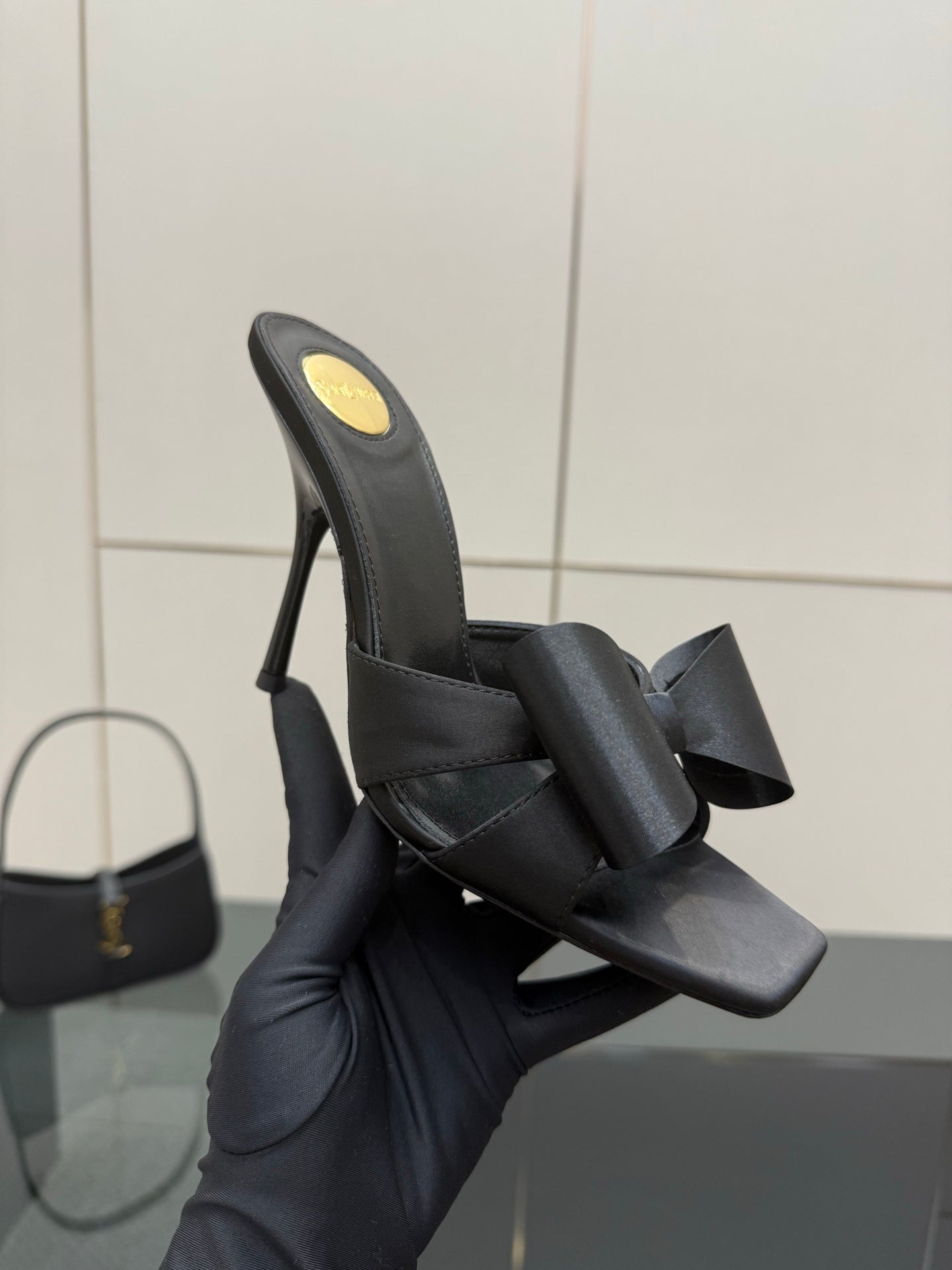 YSL black high-heel mule sandal with bow straps, close-up view on box