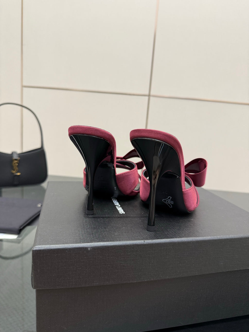 YSL pink satin bow mules, heel view and black insole detail on display box