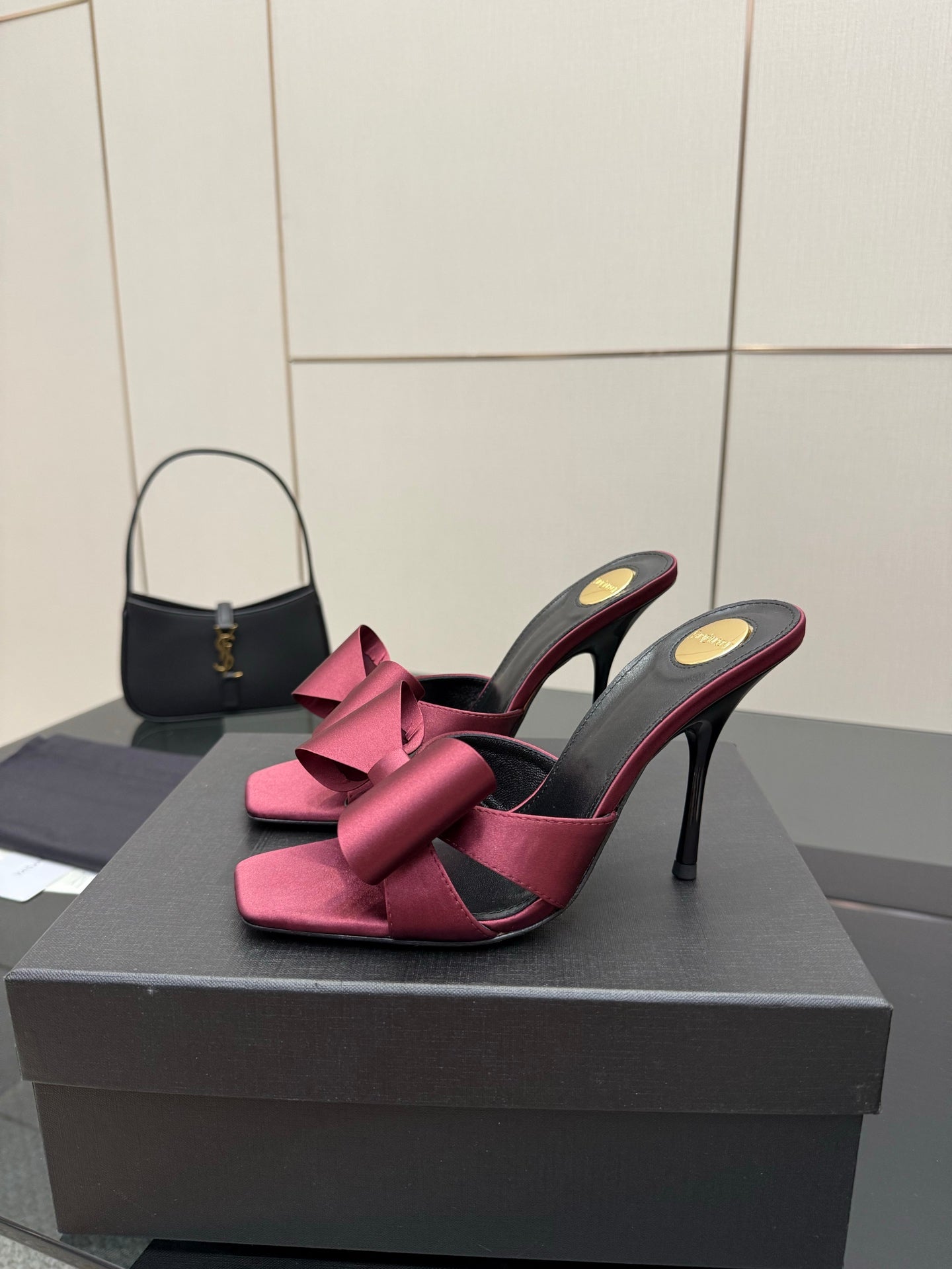 YSL pink satin bow mules on black stiletto heels, side view