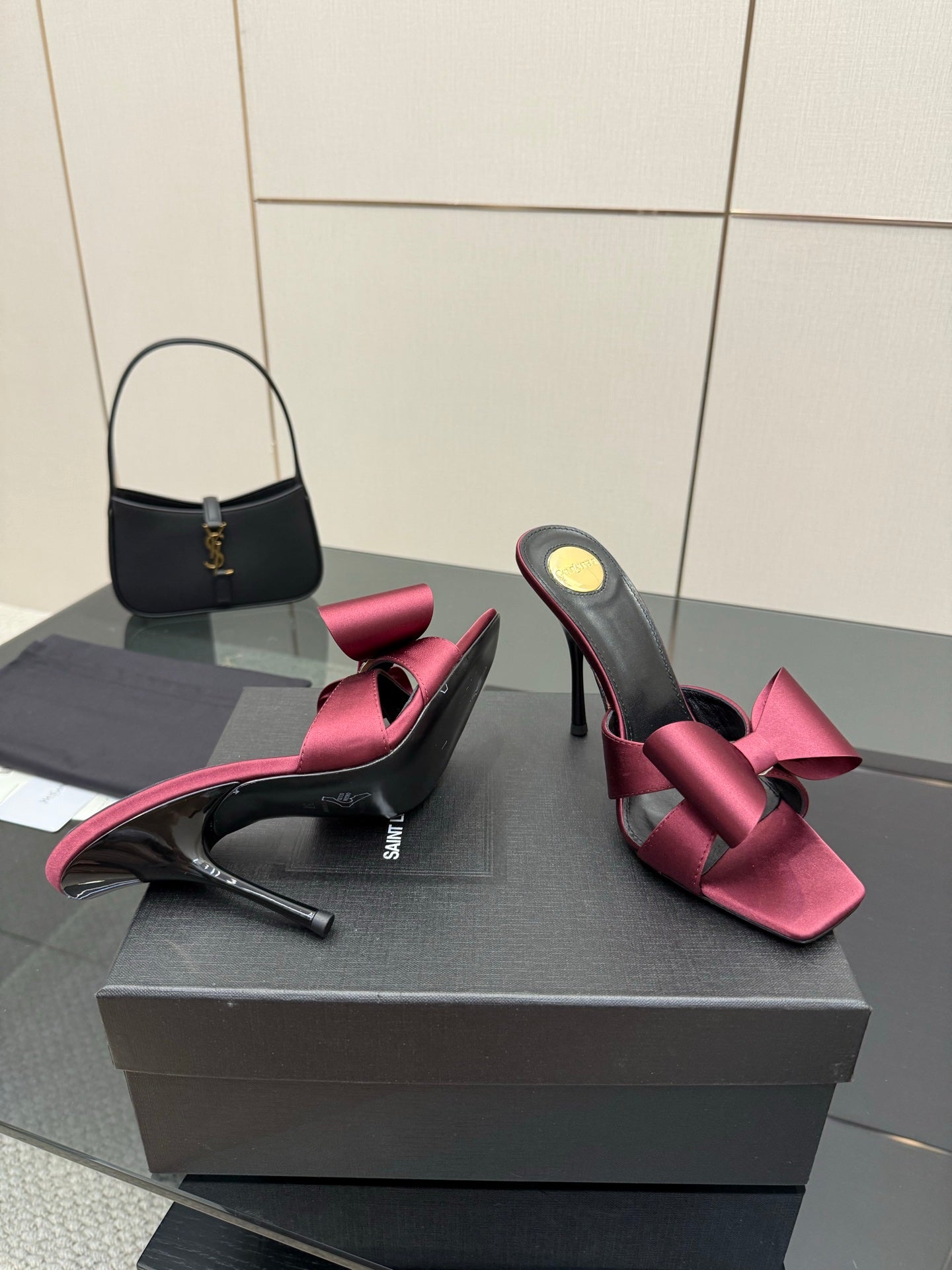 YSL pink satin bow mules with black straps and stiletto heel, front angle