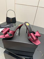 YSL pink satin bow mules with black straps and thin stiletto heels
