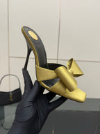 Yellow bow mules with black inner sole and tall stiletto heel