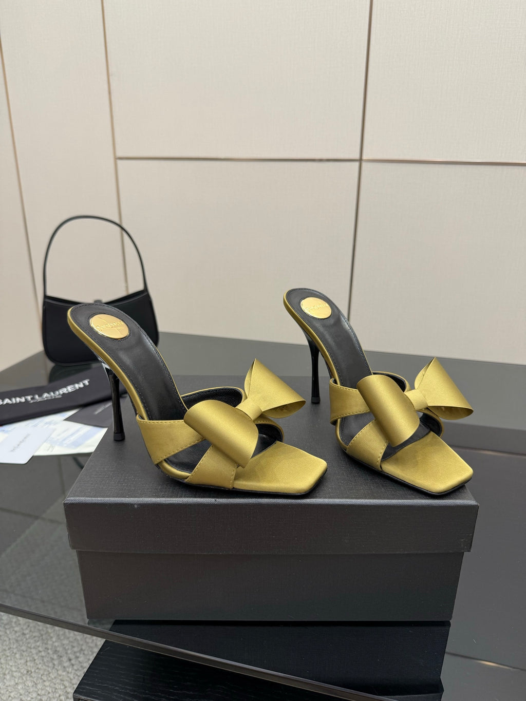 Yellow satin bow heeled mules with black lining and slim stiletto heels