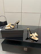 Two-tone heeled mules with beige bow on black slide straps and stiletto heel