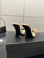 Two-tone mule heels close-up, beige upper with black interior and oval label