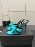 Turquoise bow mule heels with slender stiletto heel, open toe design, black lining