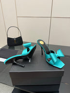 Turquoise bow mule heels, side profile with slender stiletto heel, black interior