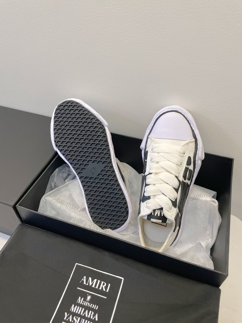 Amiri white and black lace-up sneakers, soles and tread visible