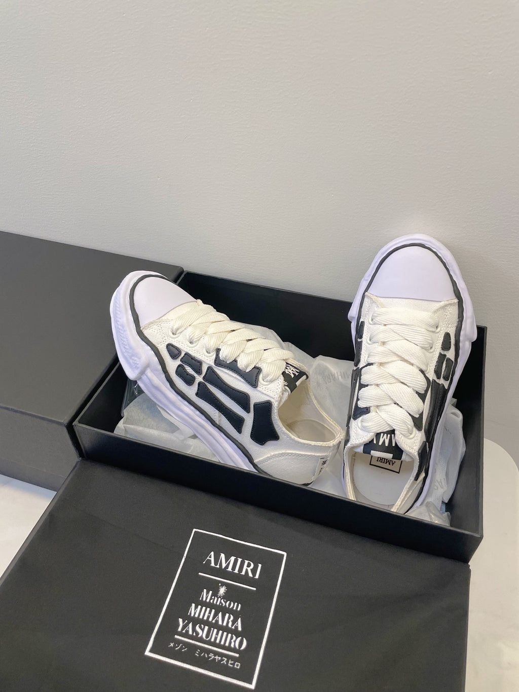 Amiri white and black lace-up sneakers, angled side view
