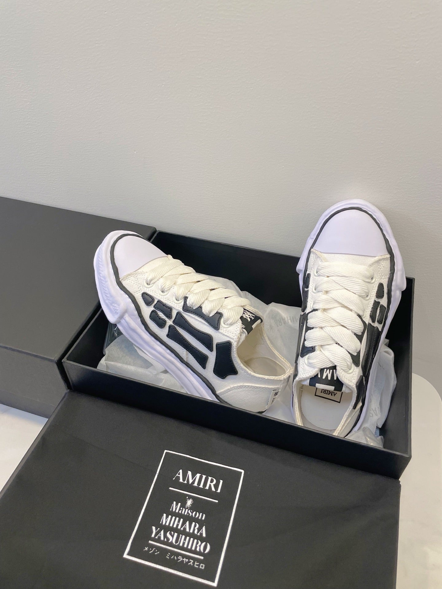 Amiri white and black lace-up sneakers, angled side view