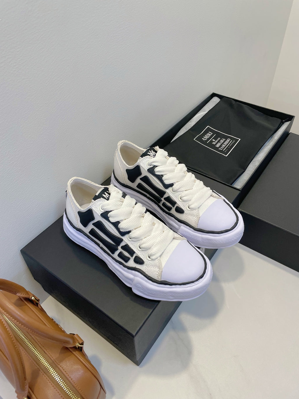 Amiri white and black lace-up sneakers, pair on display with matching box