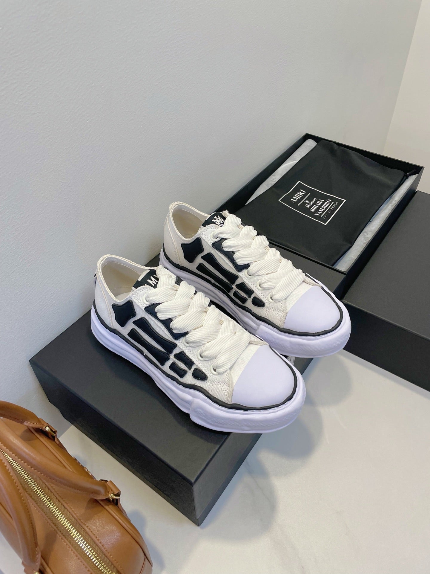 Amiri white and black lace-up sneakers, pair on display with matching box