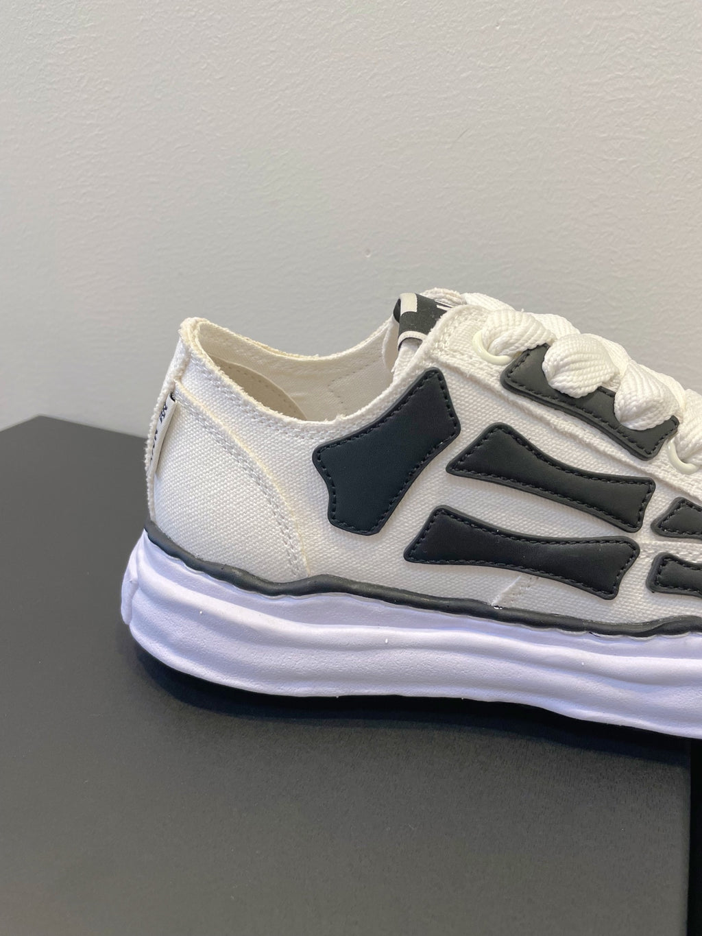 Amiri white and black lace-up sneakers, side profile close-up