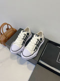 Amiri white and black lace-up sneakers, side-by-side view on display