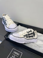 Amiri white and black lace-up sneakers, one shoe reclined on box