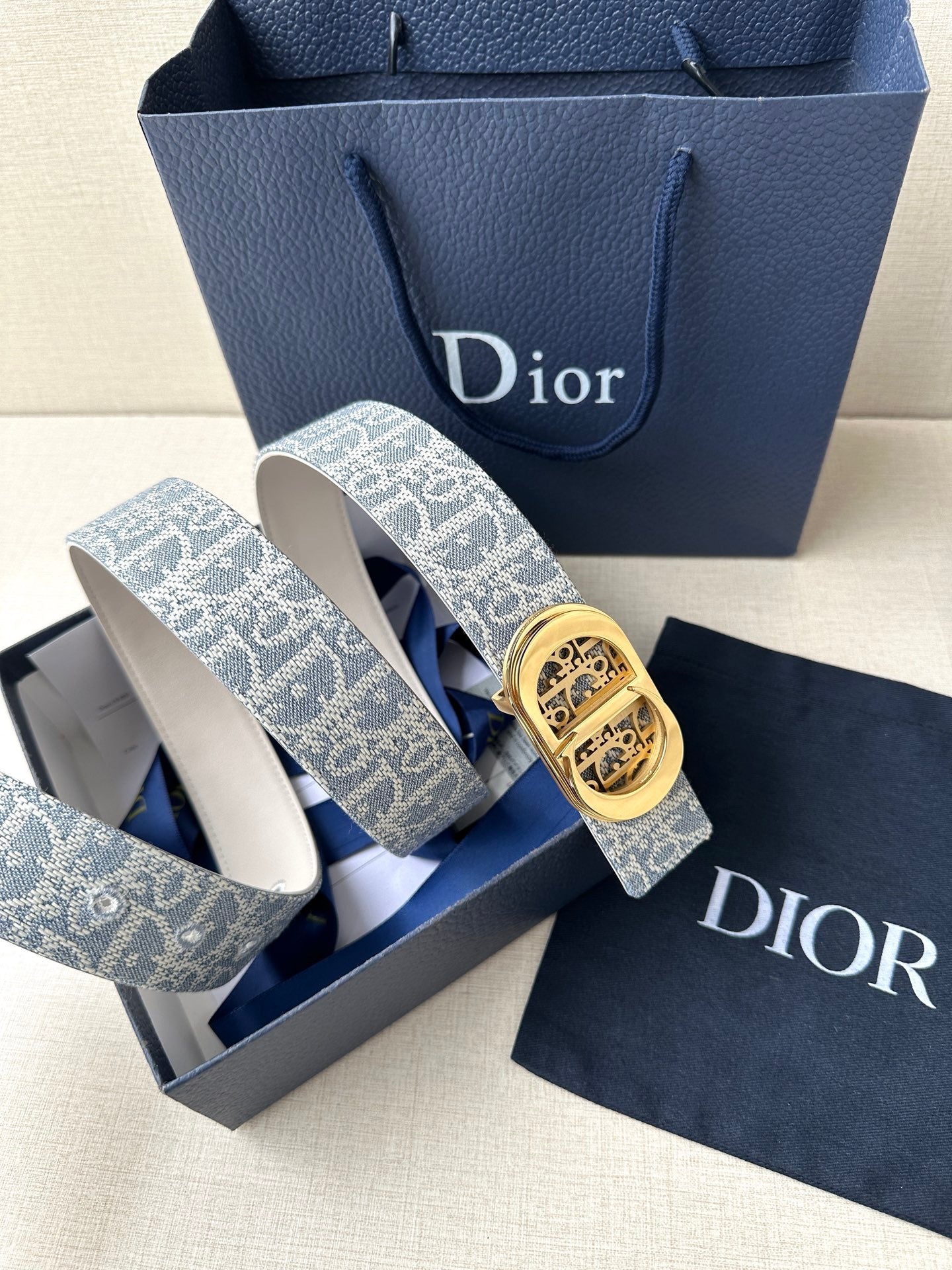 Dior belt with blue-and-white monogram strap and gold-tone engraved buckle