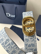 Dior belt with gold-tone buckle featuring engraved design on blue monogram strap