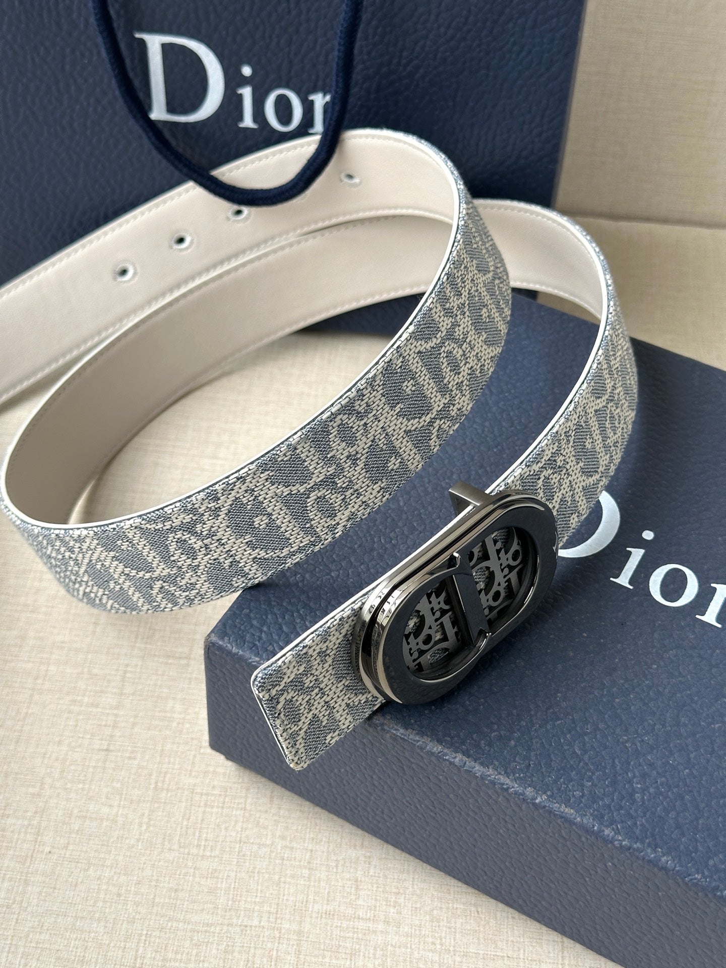 Dior belt with blue monogram strap, silver buckle, and white leather lining