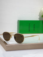 Bottega Veneta round sunglasses with gold-tone metal frame and dark brown tinted lenses