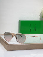 Bottega Veneta round sunglasses with gold-tone metal frame and rose-tinted lenses