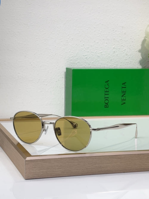 Bottega Veneta round sunglasses with gold-tone metal frame and amber tinted lenses