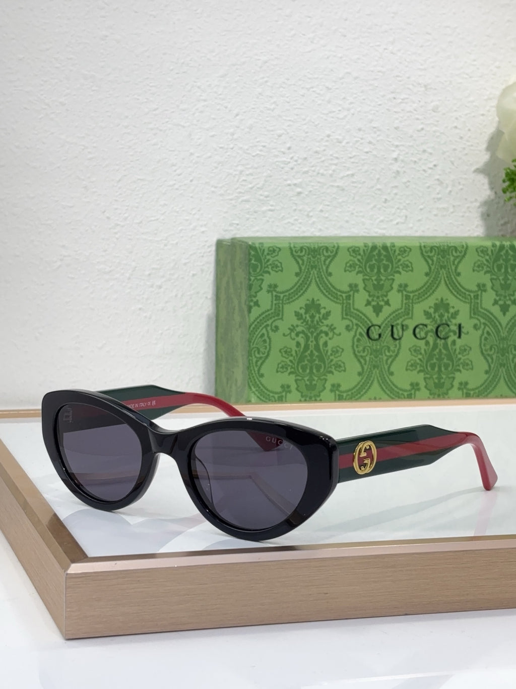 Sunglasses with black frame, smoky lenses, and red-and-black striped temple arms