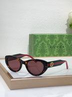 Sunglasses with black frame, warm brown tinted lenses, and red-and-black striped arms