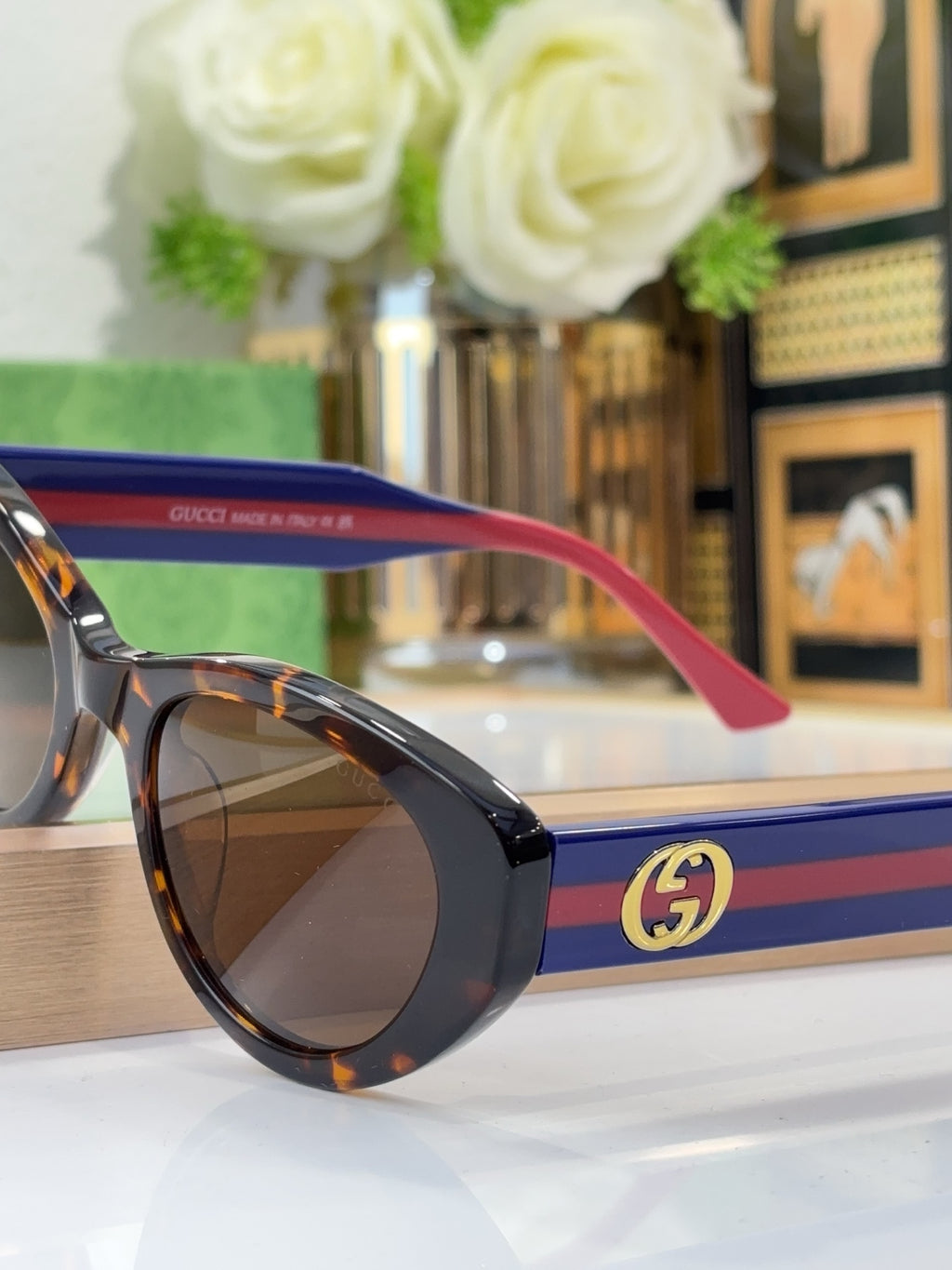 Sunglasses with tortoiseshell frame and blue-red striped temple featuring GG logo