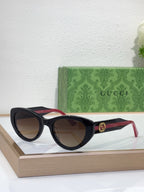 Sunglasses with black frame, gradient brown lenses, and red-and-black striped temples