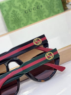 Sunglasses temple close-up with GG emblem on red-and-blue striped arm