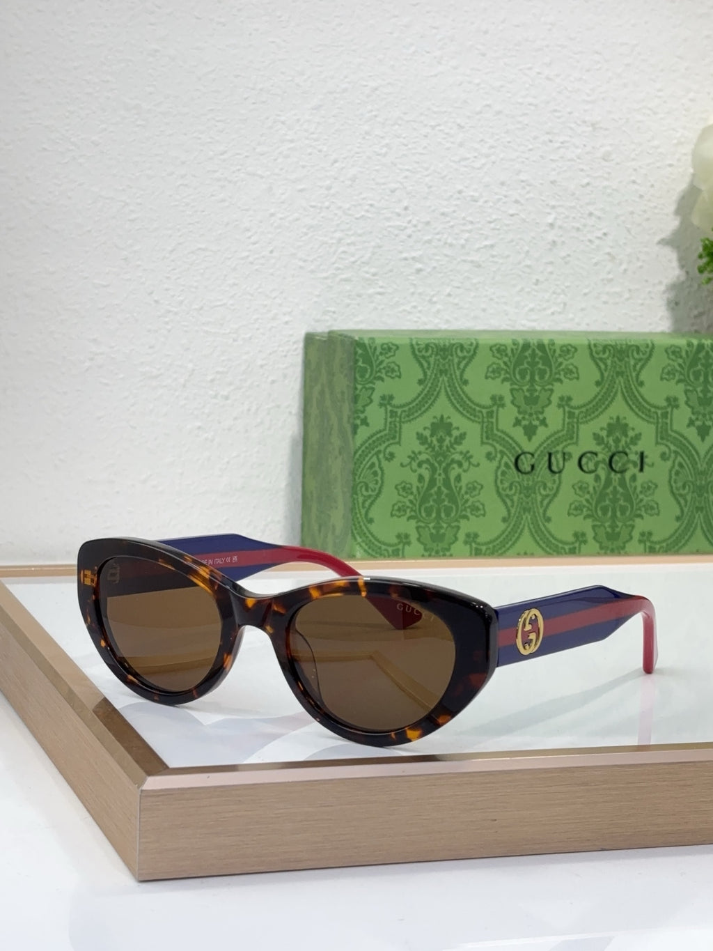 Sunglasses with dark tortoiseshell frame, tinted lenses, and red-blue striped temple arms