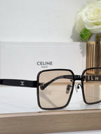 Sunglasses front close-up with black frame, dark gradient lenses, gold logo bar