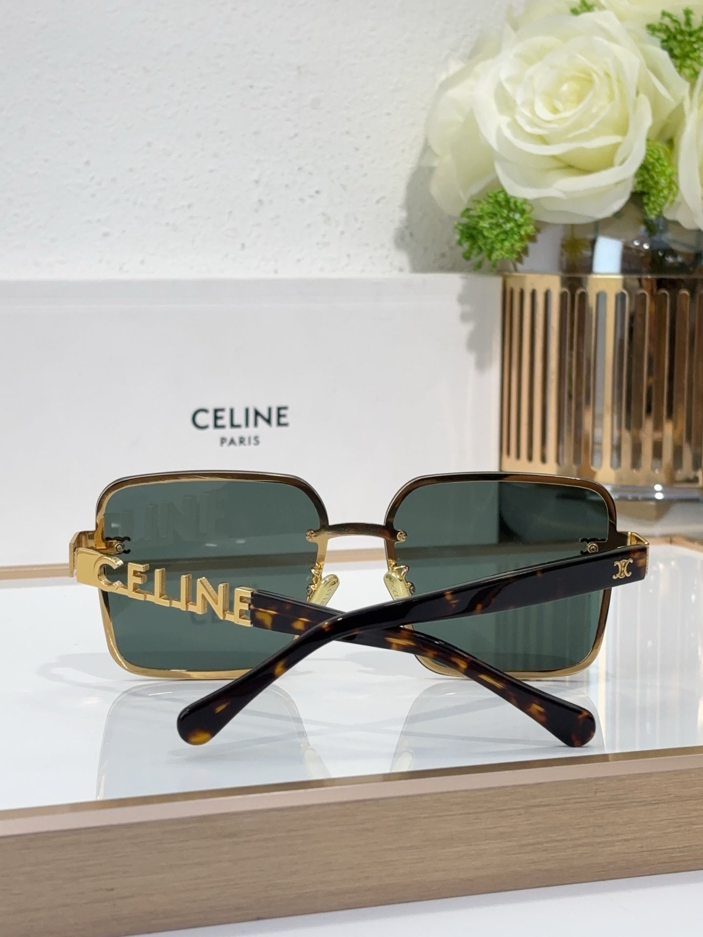 Sunglasses with tortoiseshell arms, gold-tone frame, dark tinted lenses