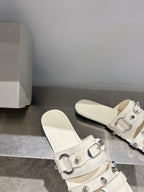 Balenciaga leather slip-on sandals in white with front buckles and open toe.