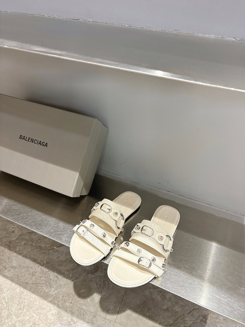 Balenciaga leather sandals in white with triple buckle straps on flat slide sole.