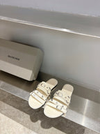 Balenciaga leather sandals in white with triple buckle straps on flat slide sole.