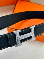 Dark blue leather belt with silver buckle close-up and embossed trim