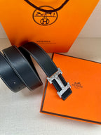Dark leather belt with silver-tone H buckle, shown with extra strap lengths