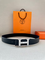 Dark leather belt with silver-tone H buckle, on a box